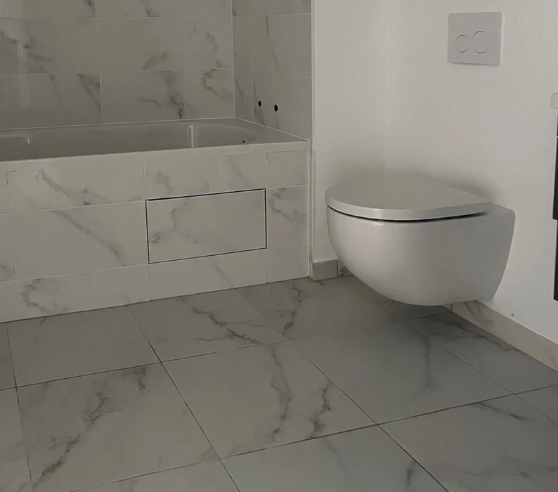 Salle de bain moderne avec toilettes suspendues blanches et meuble vasque intégré