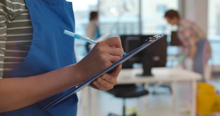 Femme de ménage nettoyant divers équipements dans le bureau